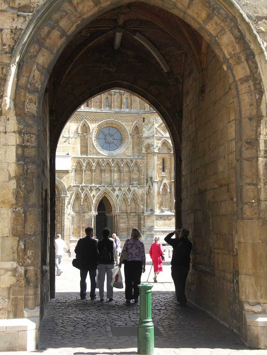 The west front of Lincoln Cathedral viewed through the Exchequer Gate, one of a number of surviving gates in the Cathedral Close walls