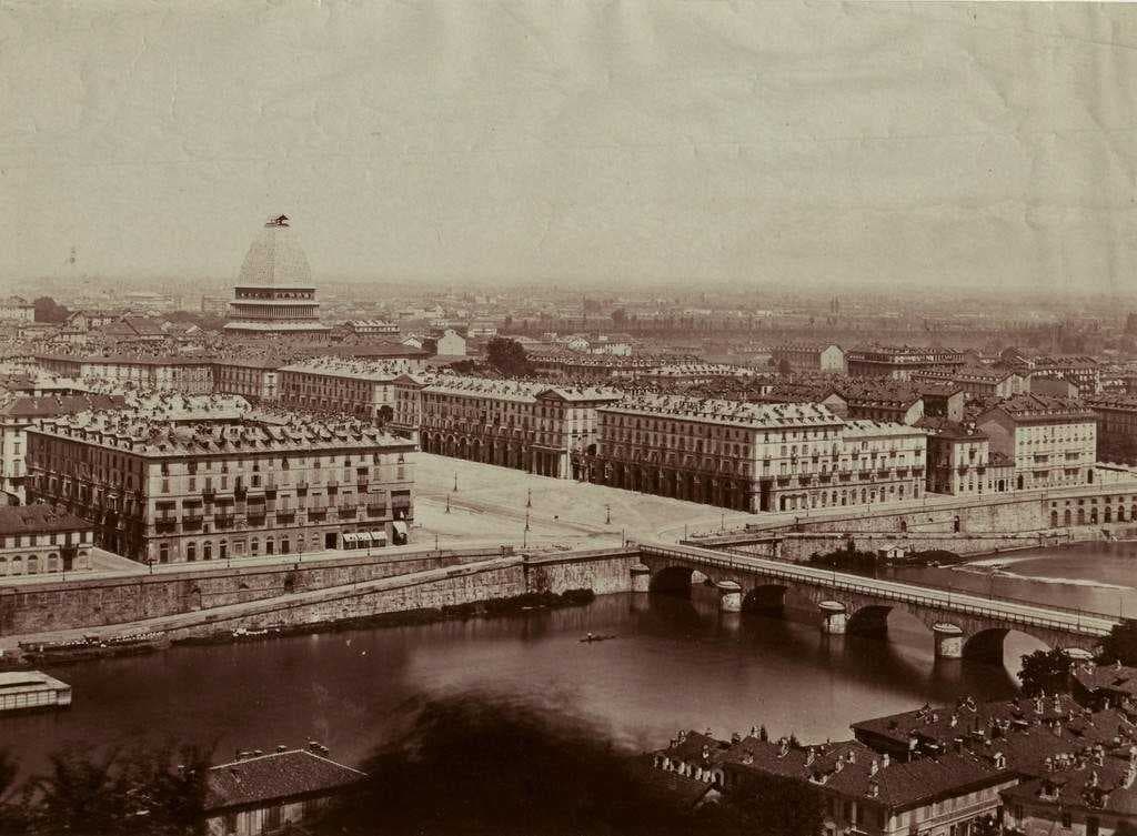 A view of Turin in the late 19th century. In the background, the Mole Antonelliana under construction.