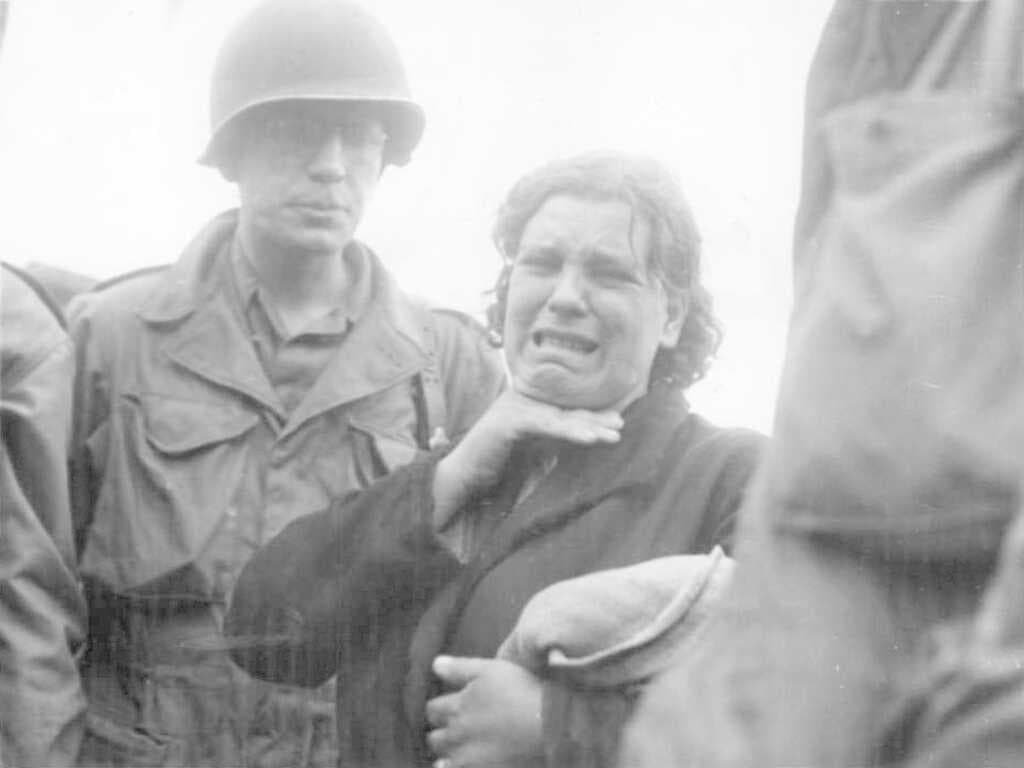 A Polish woman weeps as she tells American soldiers of her life as a slave labourer for the Nazis. She was liberated in Augsburg when the third largest Bavarian city fell to the Americans (23 April 1945).