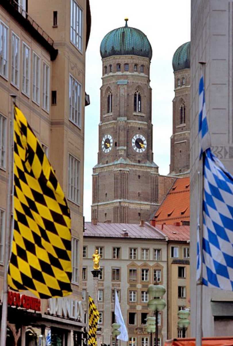 Banners with the colours of Munich (left) and Bavaria (right) with the Frauenkirche in the background