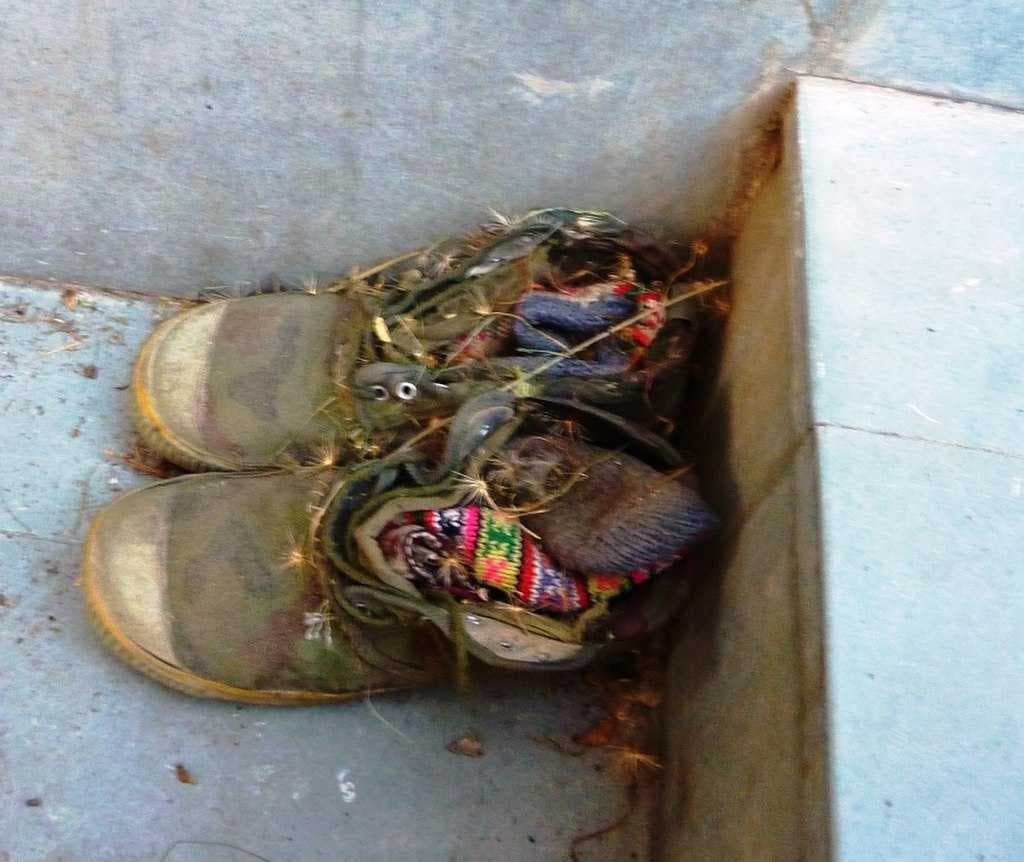 Pilgrim's shoes showing local knitted socks and straw stuffing outside temple.