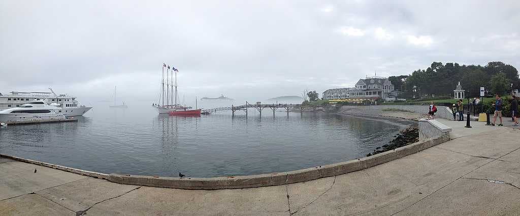 The four-masted schooner Margaret Todd; Bald Porcupine Island is beyond the pier and the Bar Harbor Inn is to the right.