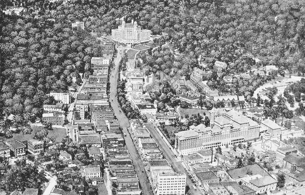 Aerial view of Hot Springs after 1925 along Central Avenue. The base of Hot Springs Mountain is in top right, behind Bathhouse Row. Part of West Mountain is on the left. The southwest edge of North Mountain is behind the Arlington Hotel at top.