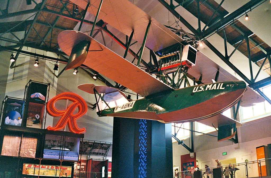 The Boeing B-1 on display in the museum's Grand Atrium, with the Rainier Brewing Company logo sign behind.