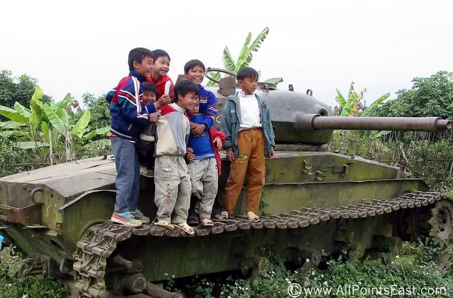 Kids standing on a tank