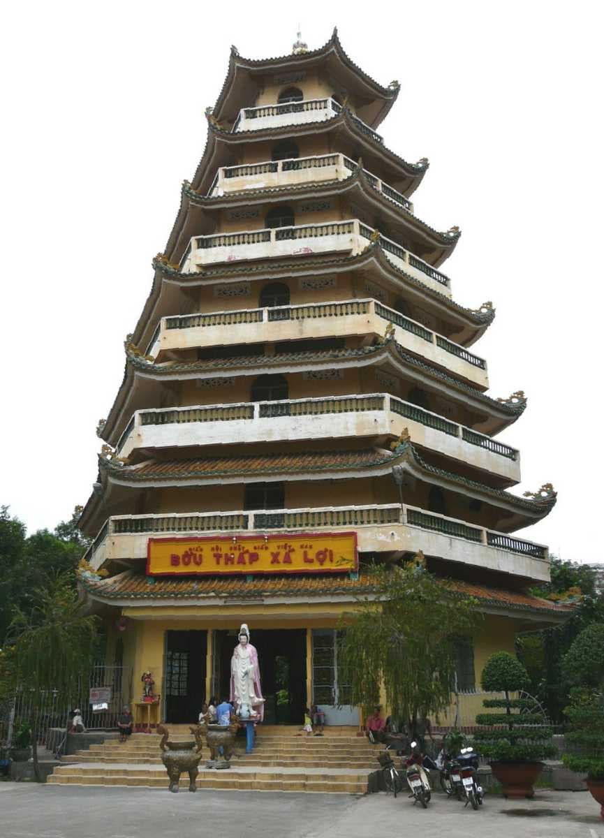 A statue of Quan Am stands at the entrance to the seven-storied stupa.